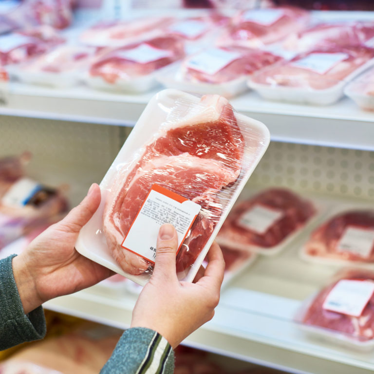 Buyer hands with pork meat at grocery